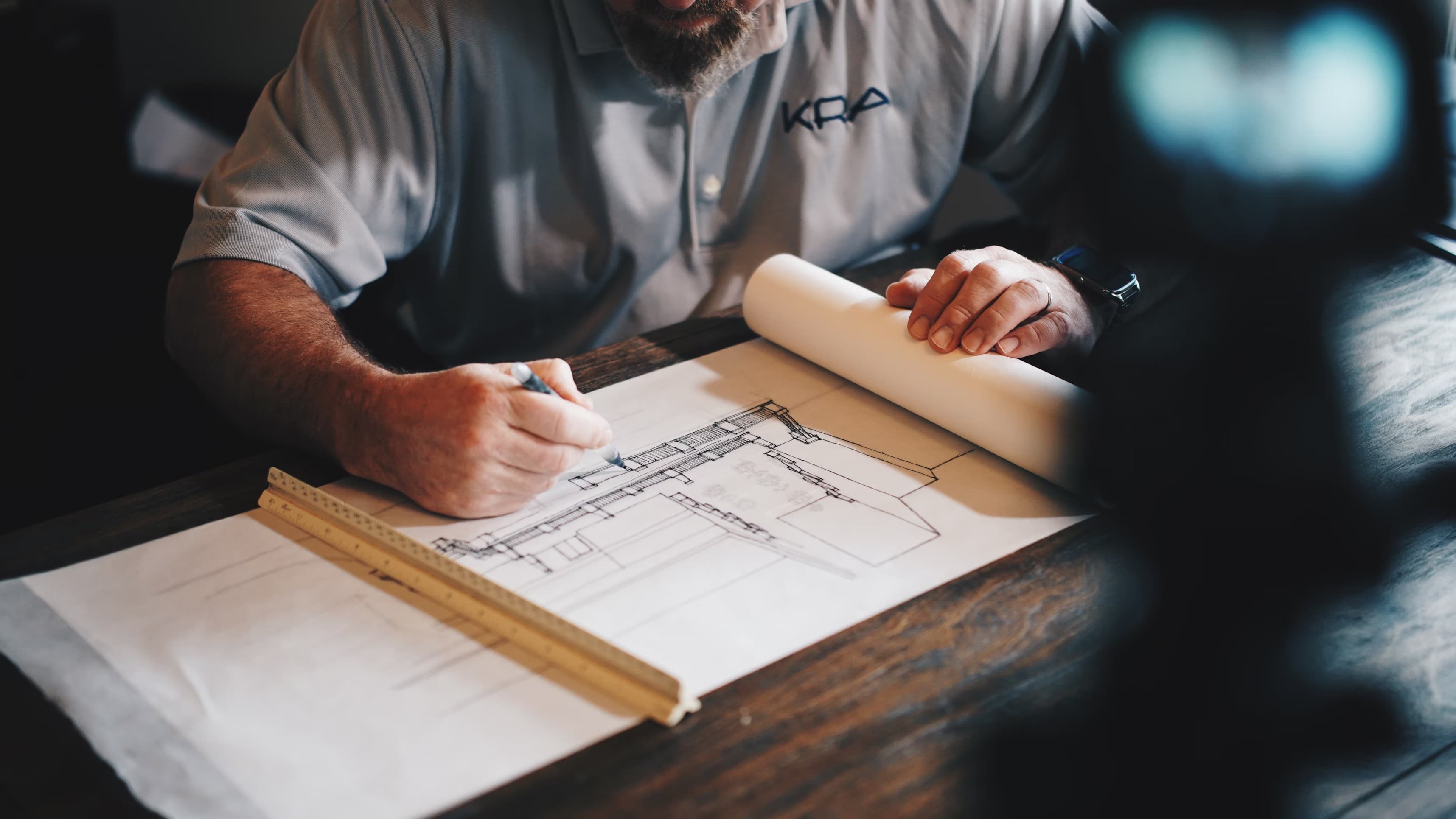 Architect reviewing blueprints with digital interface